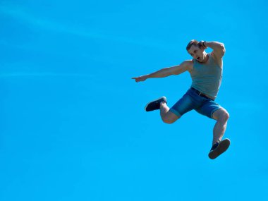 Zıplayan adam kadar. Arka plan mavi gökyüzü.