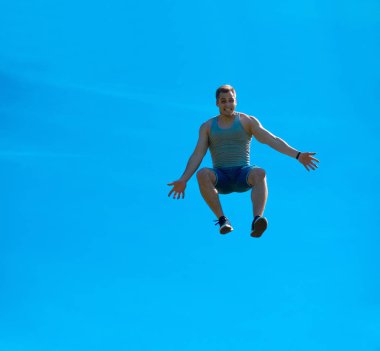Zıplayan adam kadar. Arka plan mavi gökyüzü.