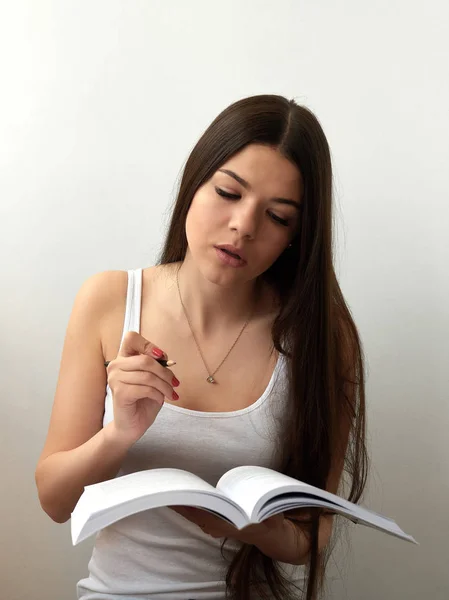 Mooie jonge mooie vrouw zitten, denkt, schrijft, nemen notities, leerboek notebook organisator in de hand houden en pen — Stockfoto