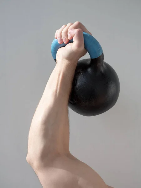 Mão de homem segurando halteres isolados em fundo cinza. Close up, conceito de estilo de vida saudável . — Fotografia de Stock