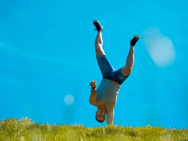 Der Typ steht auf der einen Seite. Hintergrund blauer Himmel. unter dem grünen Gras — Stockfoto