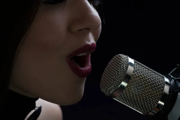 Singer in front of a microphone. Isolated on a dark background — Stock Photo, Image