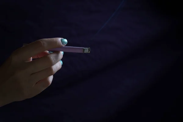 Рука женщины держит тонкую сигарету вблизи обзора — стоковое фото