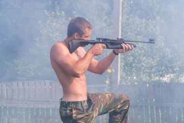 Bir adam pnömatik silah hedeften vurur. Taraftan bir kişinin görünümü