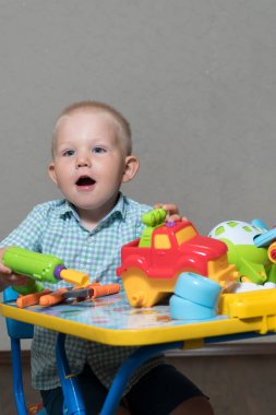 Bir çocuk oyuncak pense ve matkap ile otomobil tamir