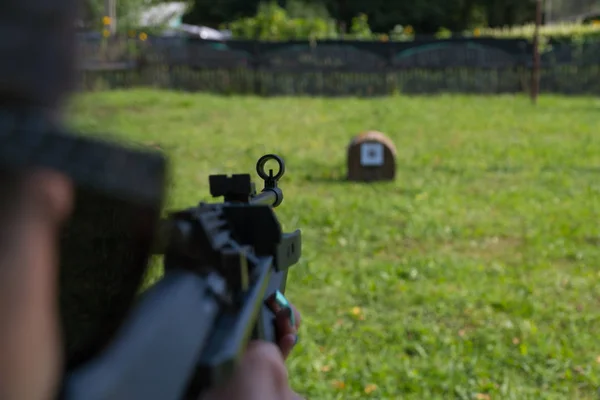 Une fille tire sur une cible d'un pistolet pneumatique — Photo