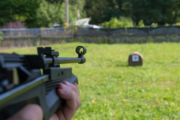 En man skjuter ett mål från en pneumatisk pistol. En vy från bakom axeln — Stockfoto
