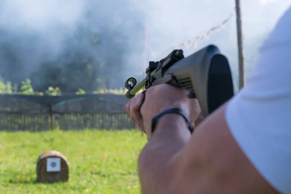 Muž střílí cíl z pneumatické zbraně. Pohled přes rameno — Stock fotografie