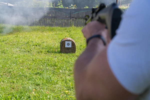 Bir adam pnömatik silah hedeften vurur. Omuz arkadan görünüm — Stok fotoğraf