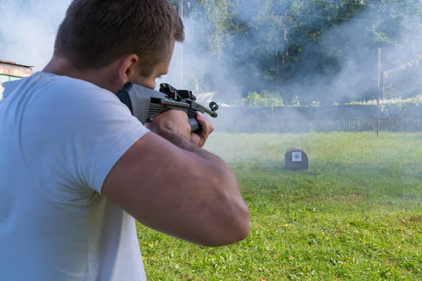 Bir adam pnömatik silah hedeften vurur. Bir adamın arkadan görünüş — Stok fotoğraf