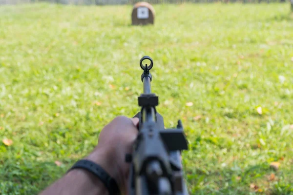 Un uomo spara a un bersaglio da una pistola pneumatica. Una vista da dietro la spalla — Foto Stock