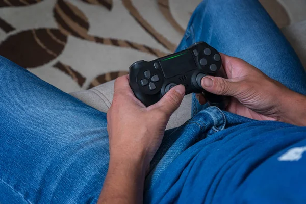 El joystick de la consola está cerca de las manos de un hombre. Hombre jugando en el joystick en una consola de juegos — Foto de Stock