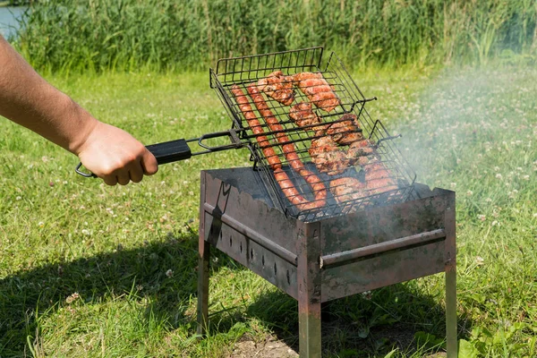 delicious bbq kebab grilling on open grill, outdoor kitchen. tasty food roasting on skewers, food-court. summer picnic