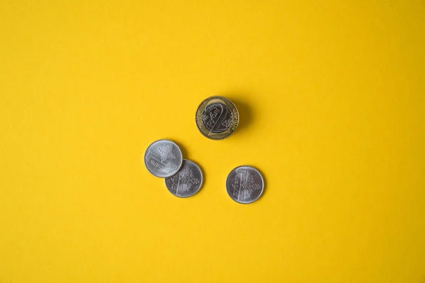 Moedas close-up em um fundo amarelo — Fotografia de Stock