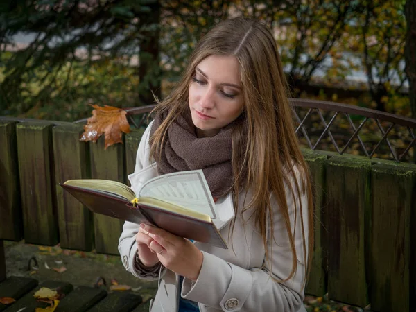 Mooie jonge vrouw leesboek in het park — Stockfoto