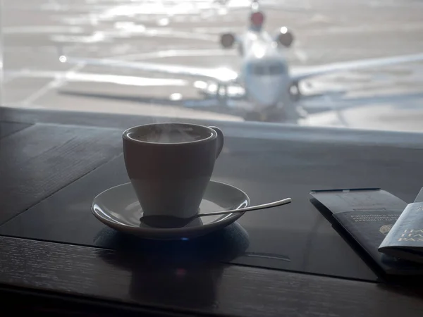 Cup of coffee in airport's business lounge with aircraft — Stock Photo, Image