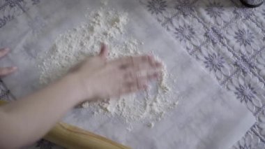 Kız temel pizza için hazırlar. Kız dışarı hamur rulo