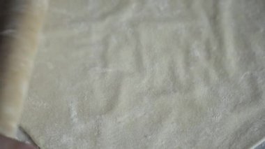 Kız temel pizza için hazırlar. Kız dışarı hamur rulo