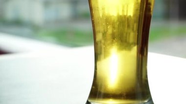 Bir bardak bira yakın çekim. Bir bardak bira pencerenin dışındaki şehir yansıtır