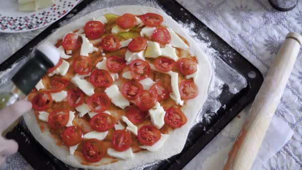 Het meisje is het koken van pizza. De kok voegt olijfolie en kruiden — Stockvideo