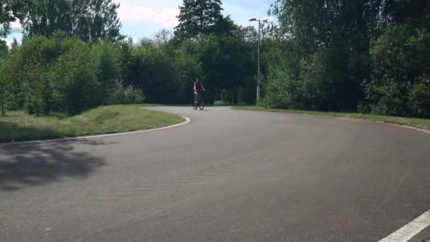 Kız bir bisiklet sürme. Önden Görünüm. Orman ve arka planda bulutlar — Stok video