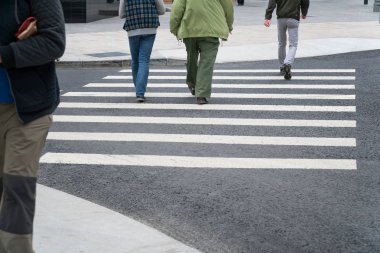 İnsanlar bir yaya geçidi üzerinde karşıdan karşıya