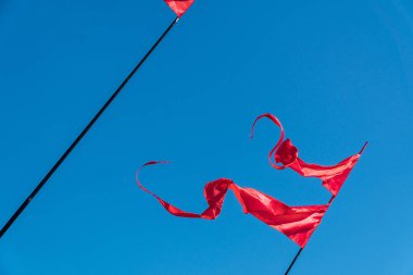 Kırmızı bayraklar rüzgara karşı mavi gökyüzü içinde çırpınan