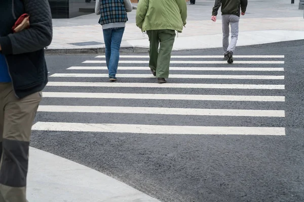 İnsanlar bir yaya geçidi üzerinde karşıdan karşıya