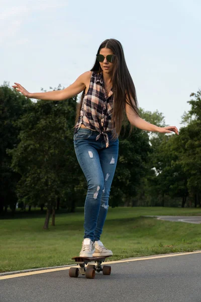 Güzel genç kız paten kaykay batımında üzerinde