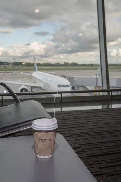 Kopje koffie in de luchthaven business lounge met vliegtuigen — Stockfoto