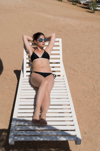 Bir tembel plajda güneşlenirken kız