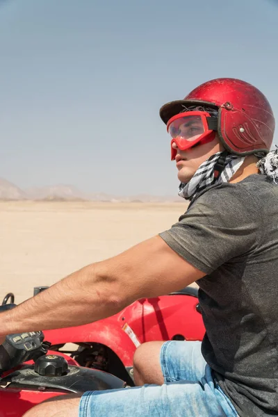 Quad - egzotik senaryolarda - kask ve macera giysili adam kavramı etkinlik tatil, özgürlük ve macera tarafından çöl gezi sırasında genç adam