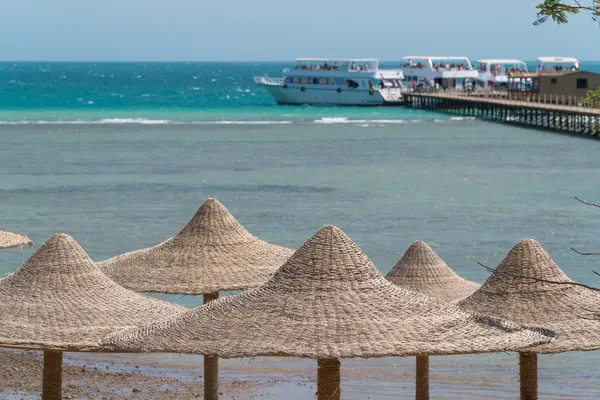 Une vue sur la mer rouge en Egypte avec des sommets en osier à partir de parasols au premier plan — Photo