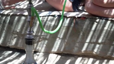 Kızlar bir Bedevi ev gölgesinde bir nargile duman.