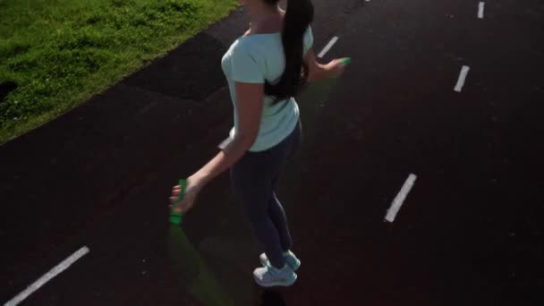 Девушка прыгает по беговой дорожке стадиона . — стоковое видео