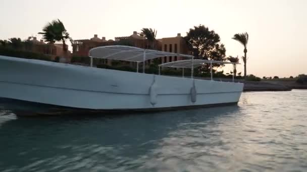 Vista de la puesta de sol en los canales de agua de la ciudad. La cámara se retira del barco en movimiento . — Vídeos de Stock