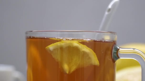 Natureza morta de chá com limão, pastilhas e termômetro, engarrafamento e bagas. O conceito de tratar resfriados . — Vídeo de Stock