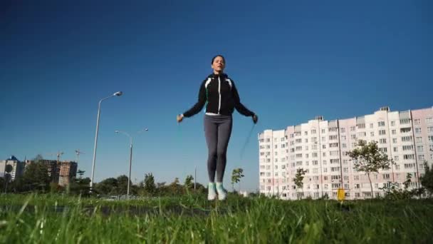 En flicka hoppar rep på ett löpband av arenan. — Stockvideo
