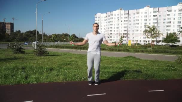 Чоловік стрибає мотузкою на біговій доріжці стадіону . — стокове відео