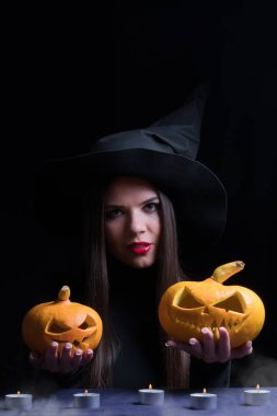 Magic kabak ile Halloween cadı. Cadı şapka ve oyulmuş kabak tutan kostüm güzel genç kadın. Cadılar Bayramı sanat tasarım