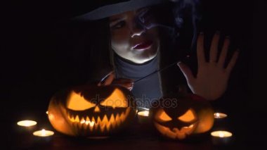 Magic kabak ile Halloween cadı. Cadı şapka ve oyulmuş kabak tutan kostüm güzel genç kadın. Cadılar Bayramı sanat tasarım.