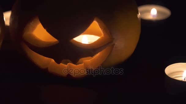 Due zucche sono sul tavolo, e le candele stanno bruciando. Design artistico di Halloween . — Video Stock