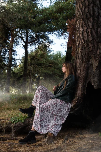 Kız büyük bir ağacın altında ve sis etrafında oturur