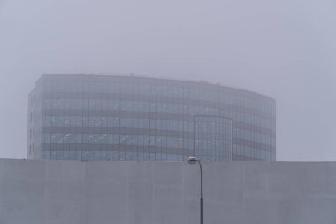 Ofis Binası yoğun sis. Başka bir bina ve bir fener ön planda olduğunu