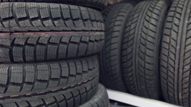 Raflarda ve sütunlarda birçok yeni kış lastikleri var. Mağazanın panoraması
