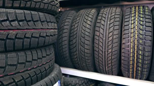 许多新的冬季轮胎挂在架子上 排成纵队 商店的全景 — 图库视频影像