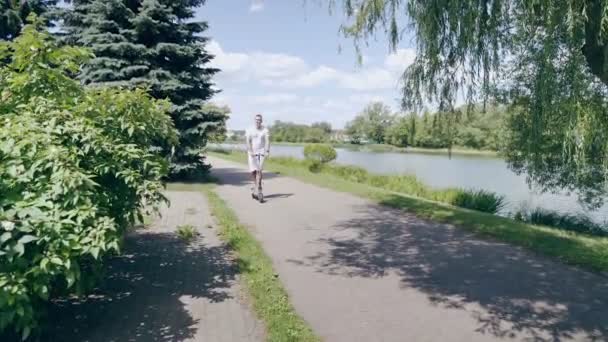 Multiethnique homme scooter électrique le long de la rivière — Video