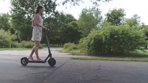 Multi-etnische vrouw rijden elektrische scooter langs de rivier — Stockvideo