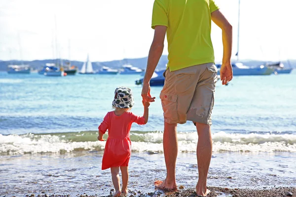 Liebender Vater mit Tochter, die sorgenfrei am Strand spaziert und — Stockfoto