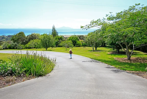 Blonďatá holčička se procházky po zahradě Aurora Lodge v Waipu — Stock fotografie